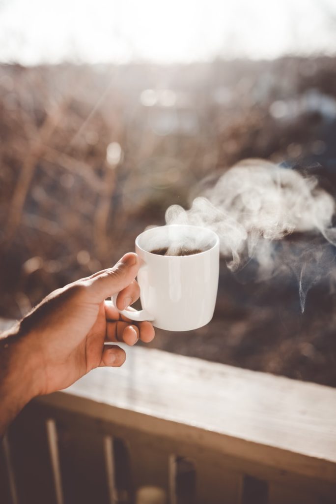 Tasse de café chaude dans une main